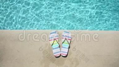 蓝色游泳池附近的彩色<strong>夏季凉鞋</strong>